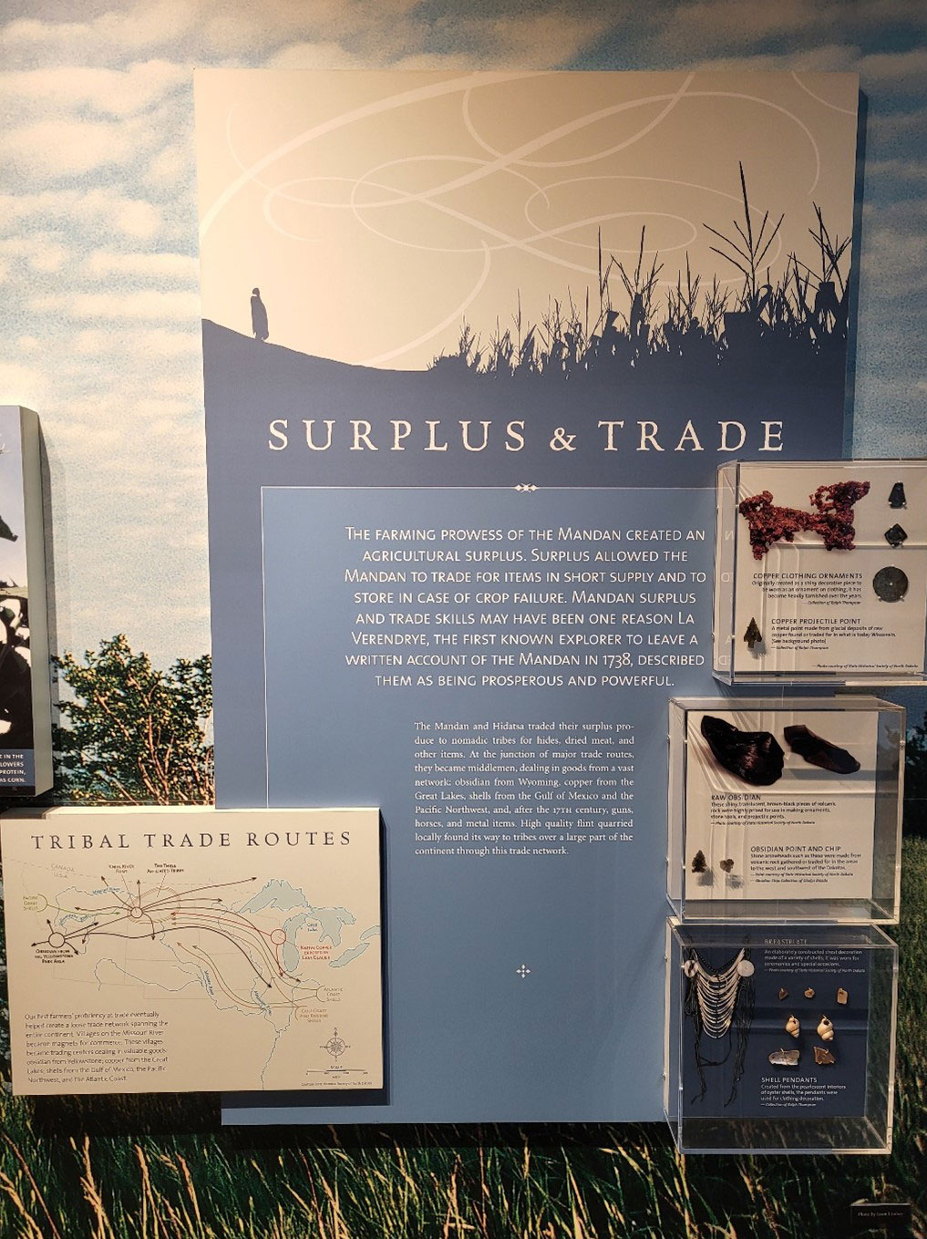Surplus and Trade exhibit with a tribal trade routes map and three small boxes with artifacts.
